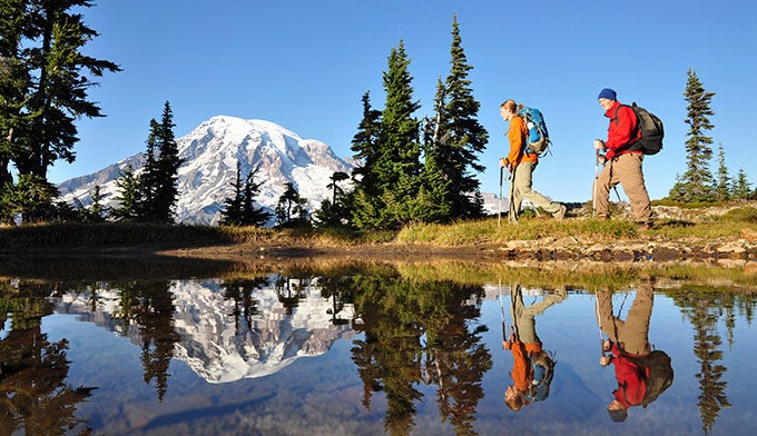 Mt-Rainier-hikers-reflection_iStock_680 Hikers with Mt Rainier reflection on water